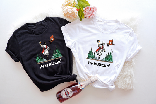 Spread some Easter cheer with this delightful "He Is Rizzin'" tee. 