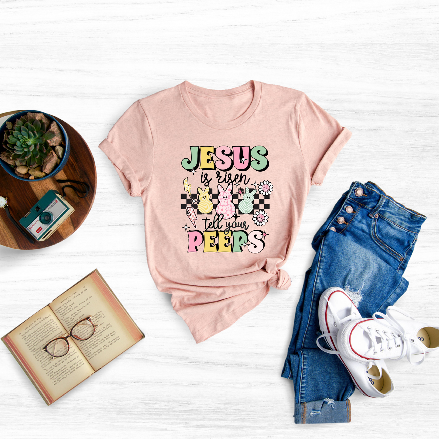 Celebrate the joyous Easter holiday with this adorable "Jesus is Risen Tell Your Peeps" toddler shirt.
