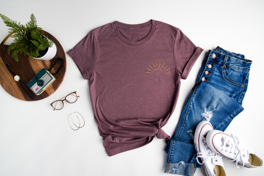 This unique tee features a vibrant embroidered sun design, adding a touch of sunshine to your wardrobe.